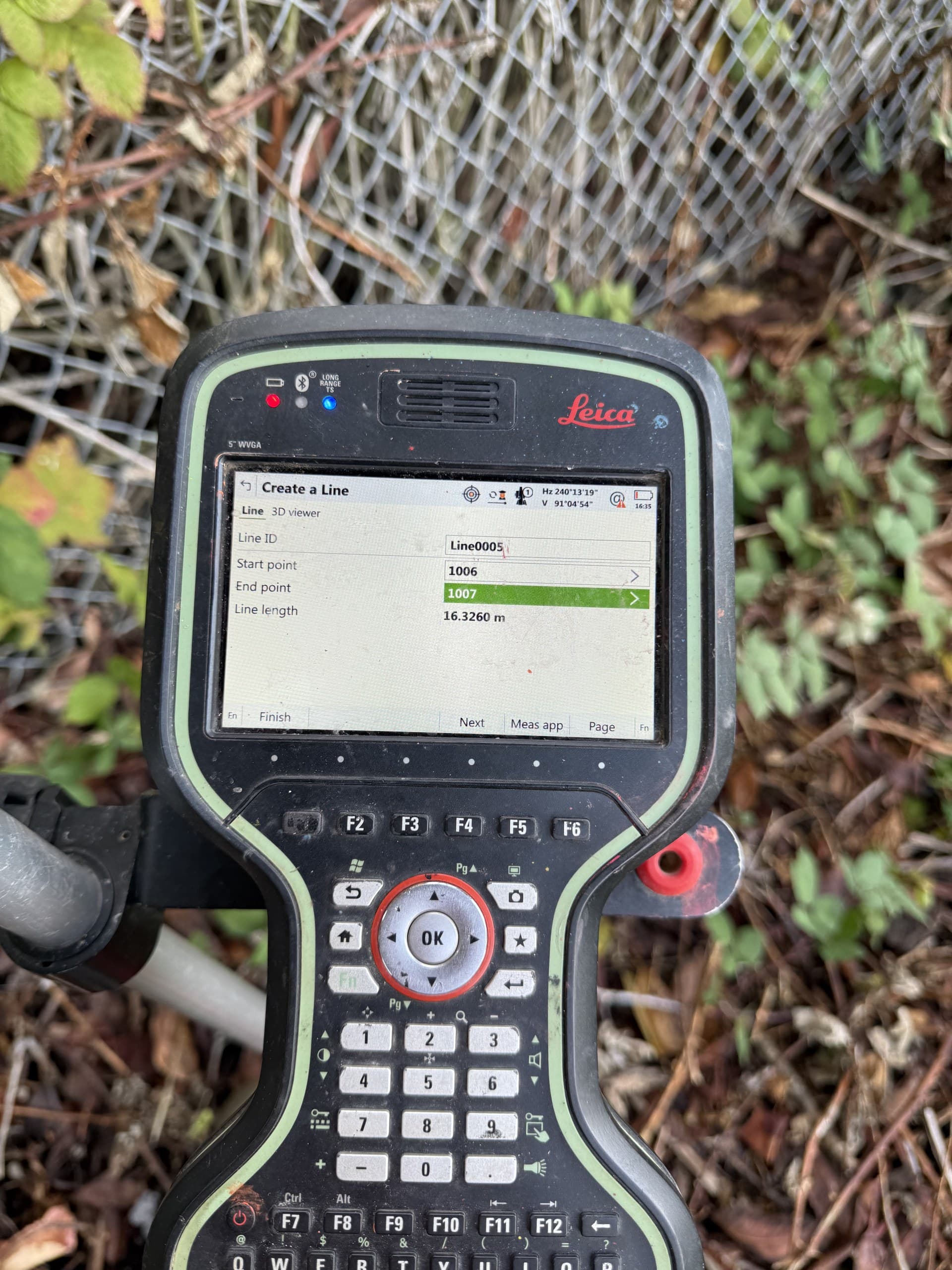 Survey controller defining a measurement line at a stockpile toe