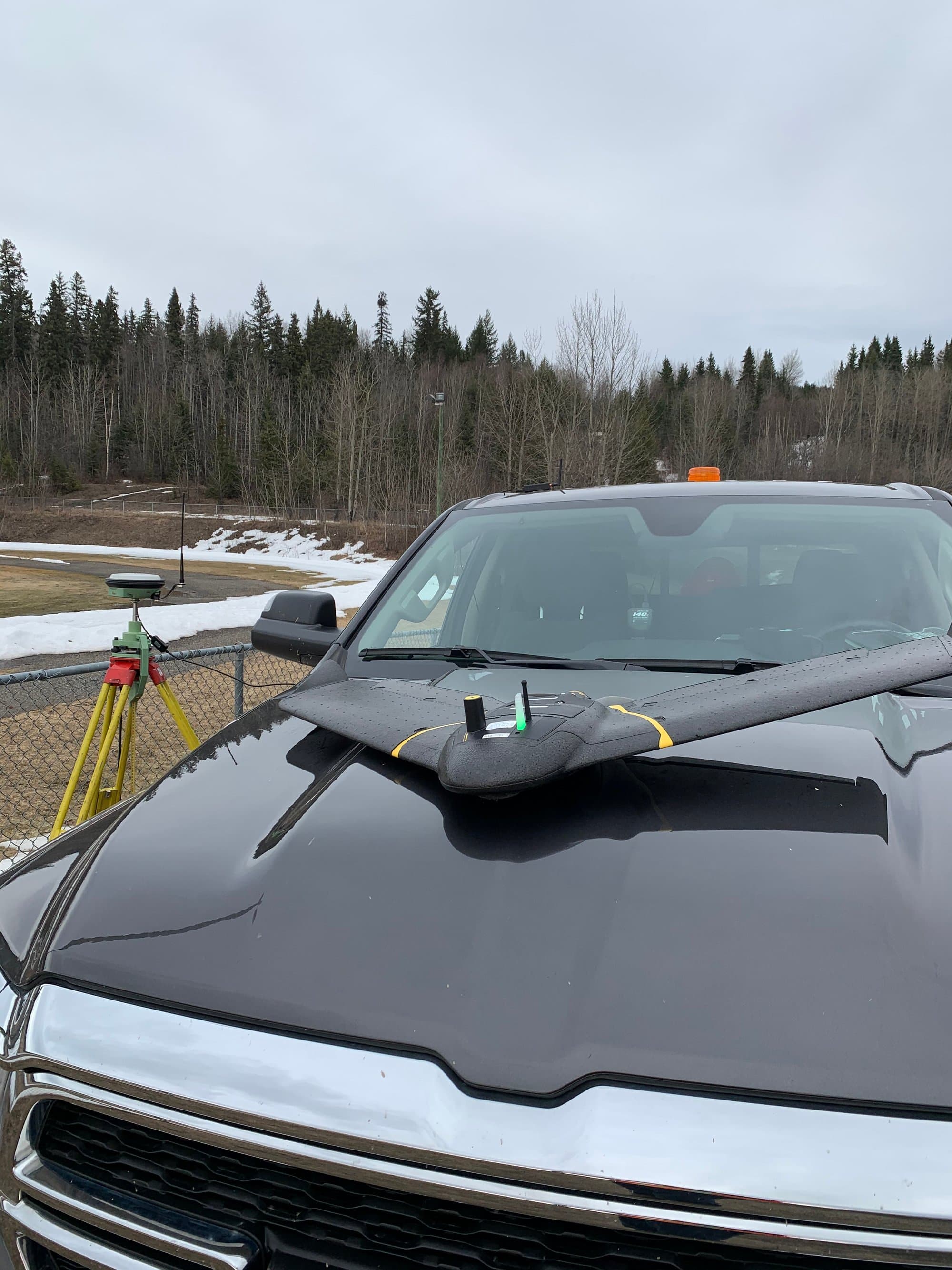 Fixed-wing mapping drone staged beside a GNSS base