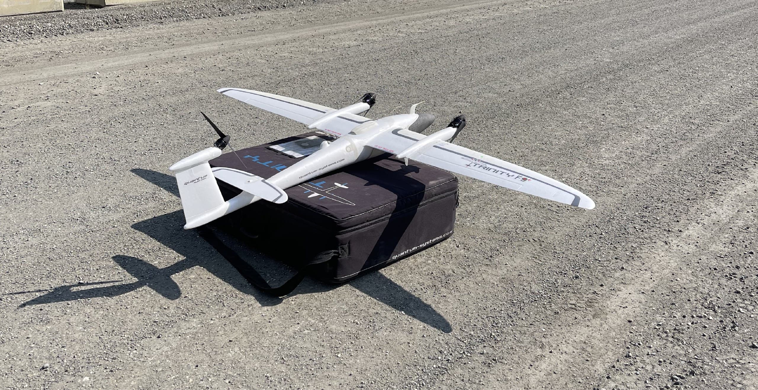Fixed-wing VTOL mapping drone staged on its field case