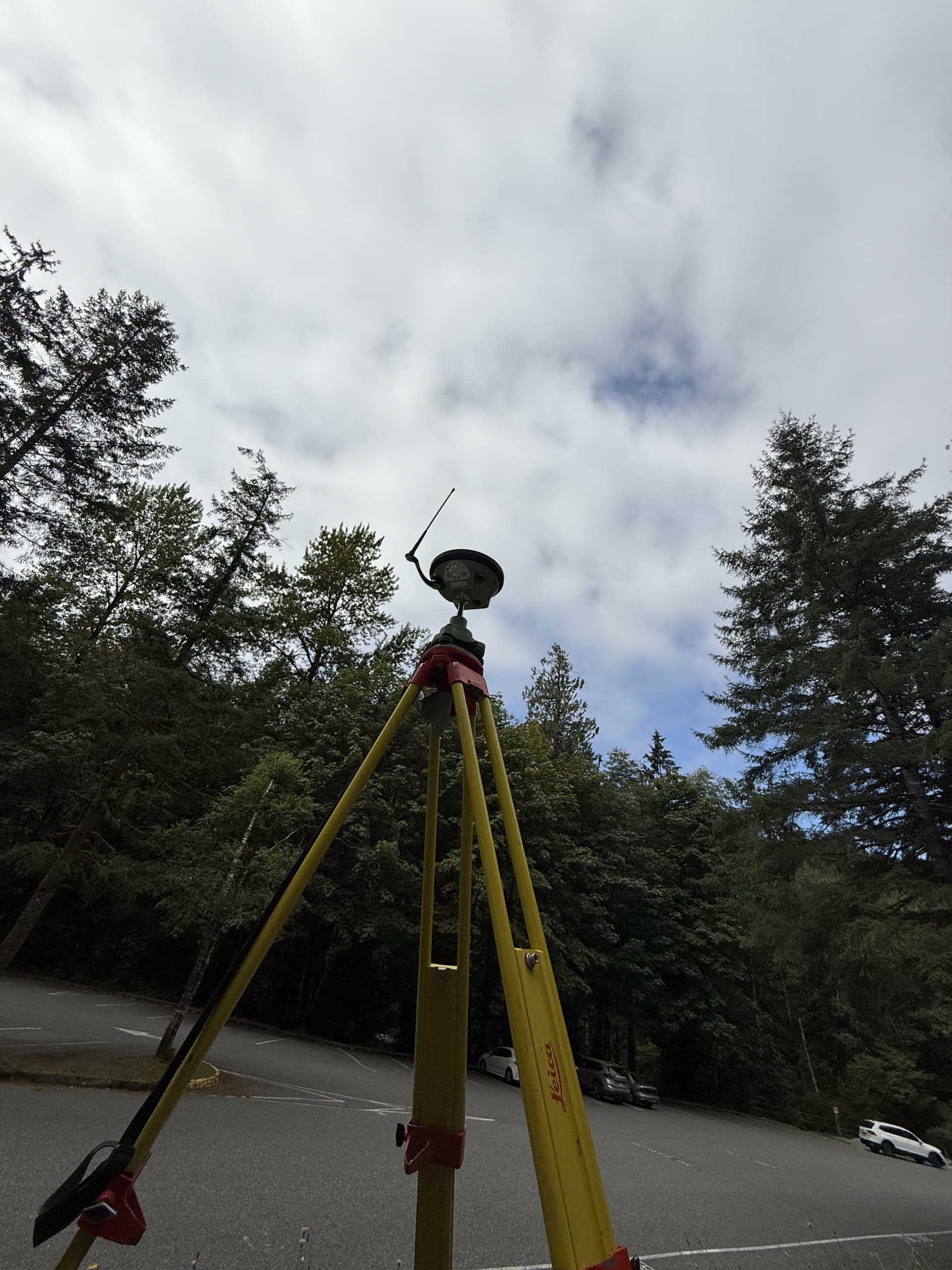GNSS base station on a tripod in a treed clearing