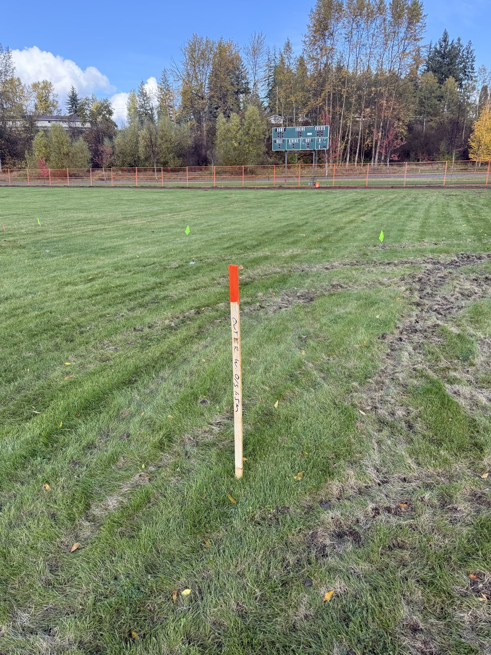 Offset stake marked with an offset distance on a fenced construction site