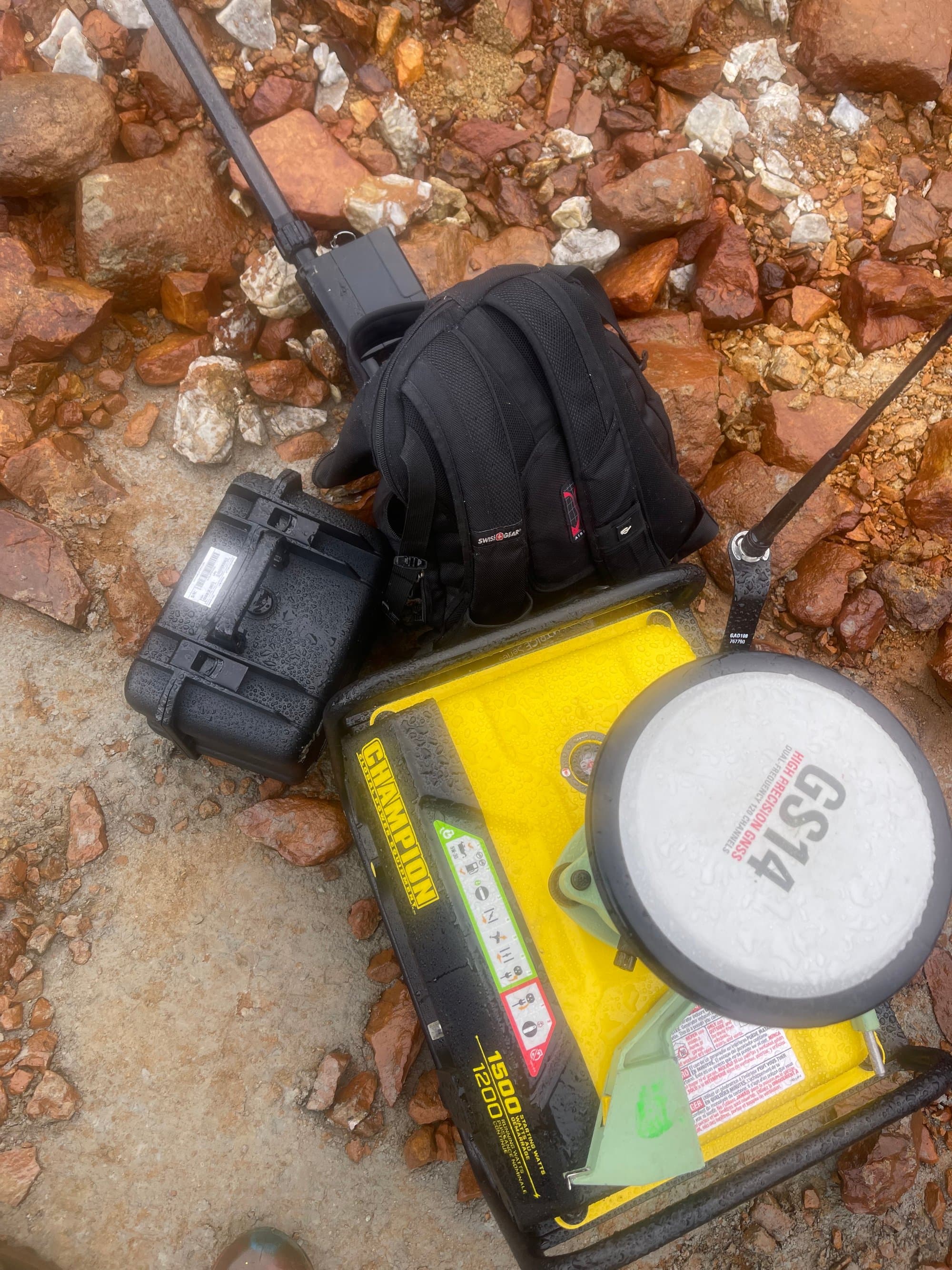 GNSS base kit running in the rain on a rocky shoreline