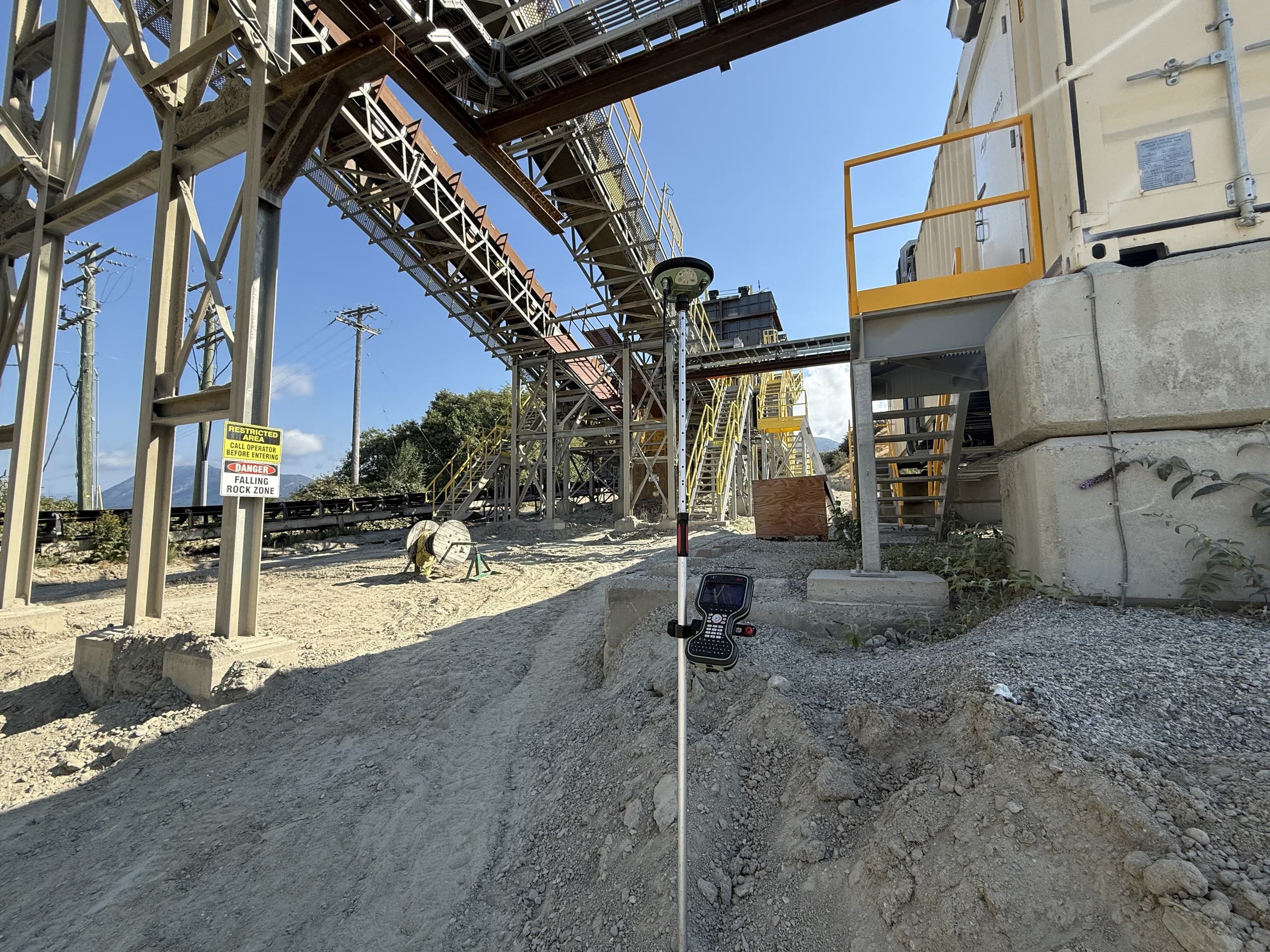 RTK rover set up beneath conveyors at an aggregate plant