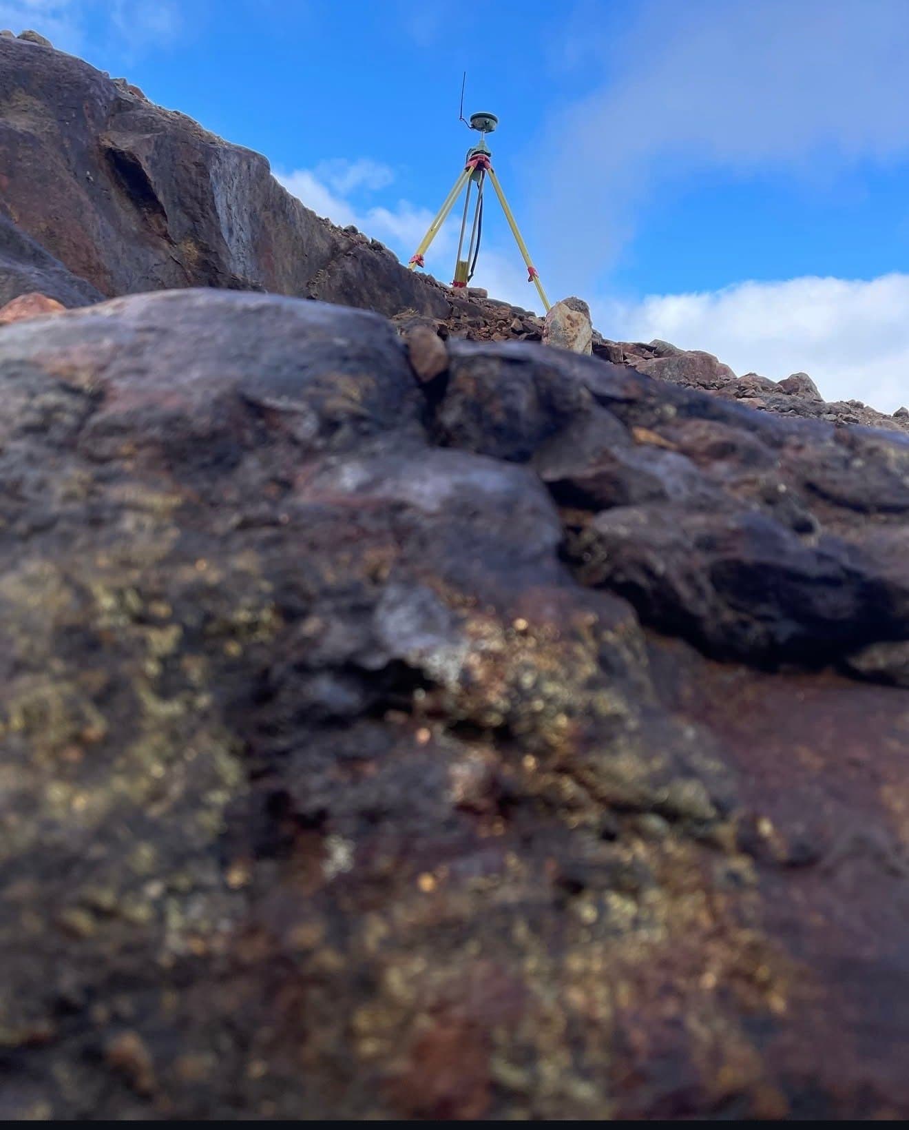 Survey tripod on a rocky summit ridge