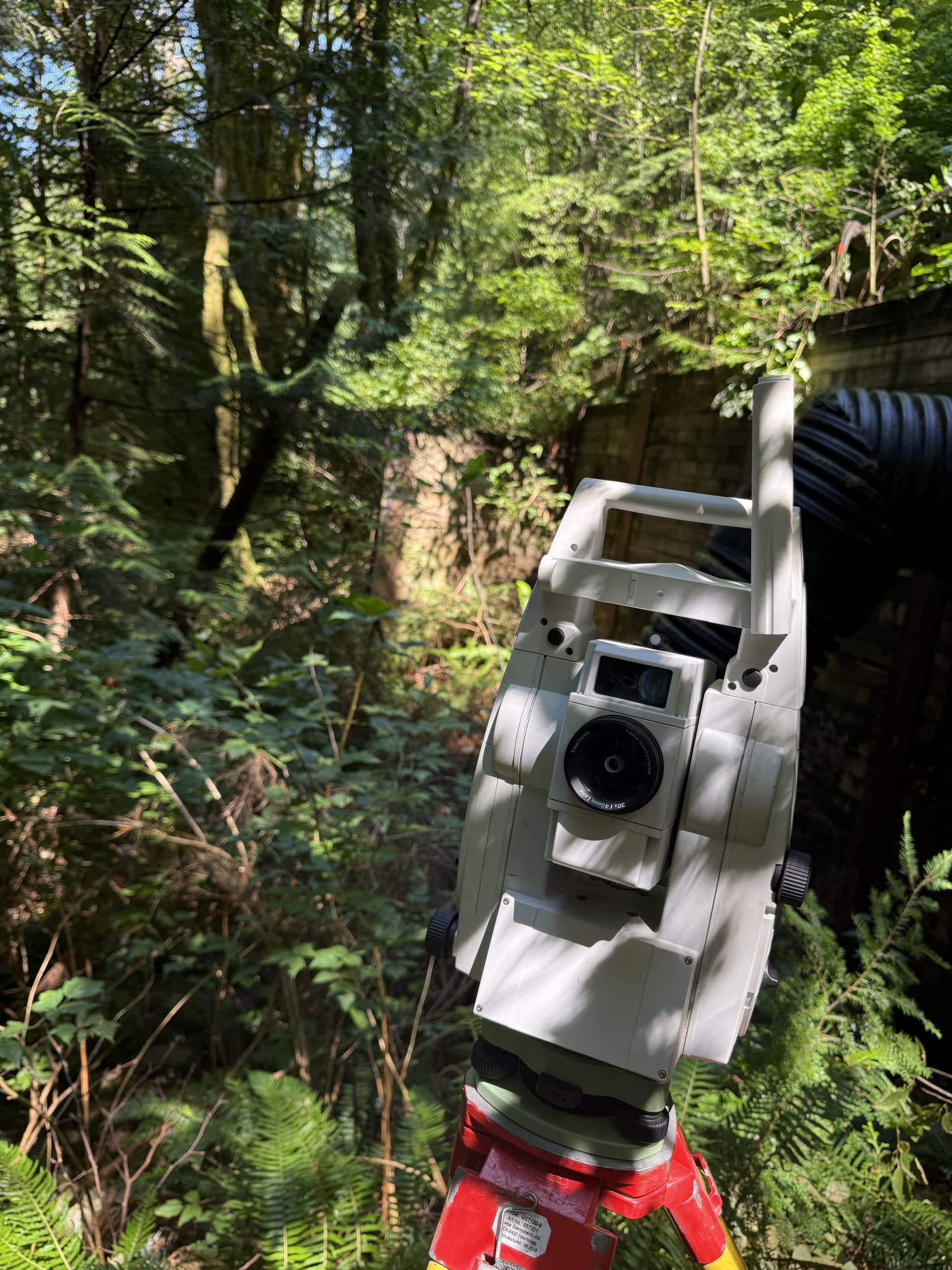 Robotic total station under forest canopy at a culvert installation