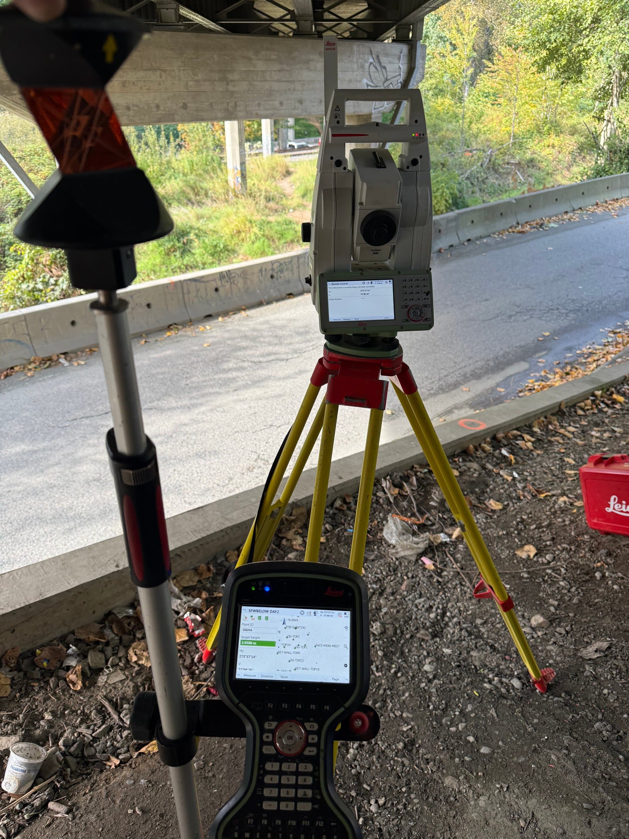 Total station and prism set up beneath an urban overpass